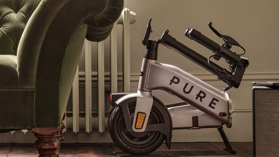 Folded Pure Advance Flex electric scooter beside a sofa